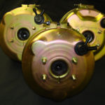 Three gold plated brake discs with a black background