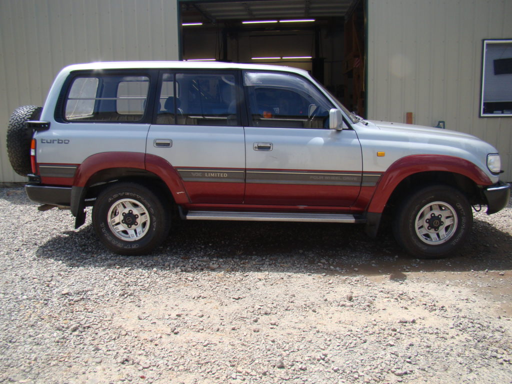 A white and red suv parked in front of a building.