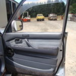 A car door open with the driver 's side view mirror on.