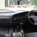 A car dashboard with the steering wheel and dash.