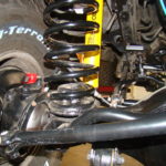 A close up of the front suspension and springs on a vehicle.