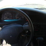 A car dashboard with the steering wheel turned to the left.