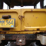 A yellow train car with an old license plate.