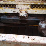 A close up of the front part of an old truck.