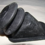 A black rubber object sitting on top of a bed.