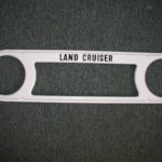A white metal object with the words land cruiser written on it.