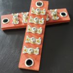 A cross made out of wood and electrical components.