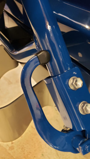 A close up of the handle on a blue chair.