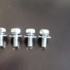 A group of four bolts sitting on top of a table.