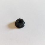 A black nut sitting on top of a white table.