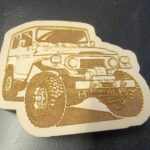 A wooden coaster with an image of a jeep.