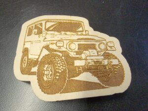 A wooden coaster with an image of a jeep.